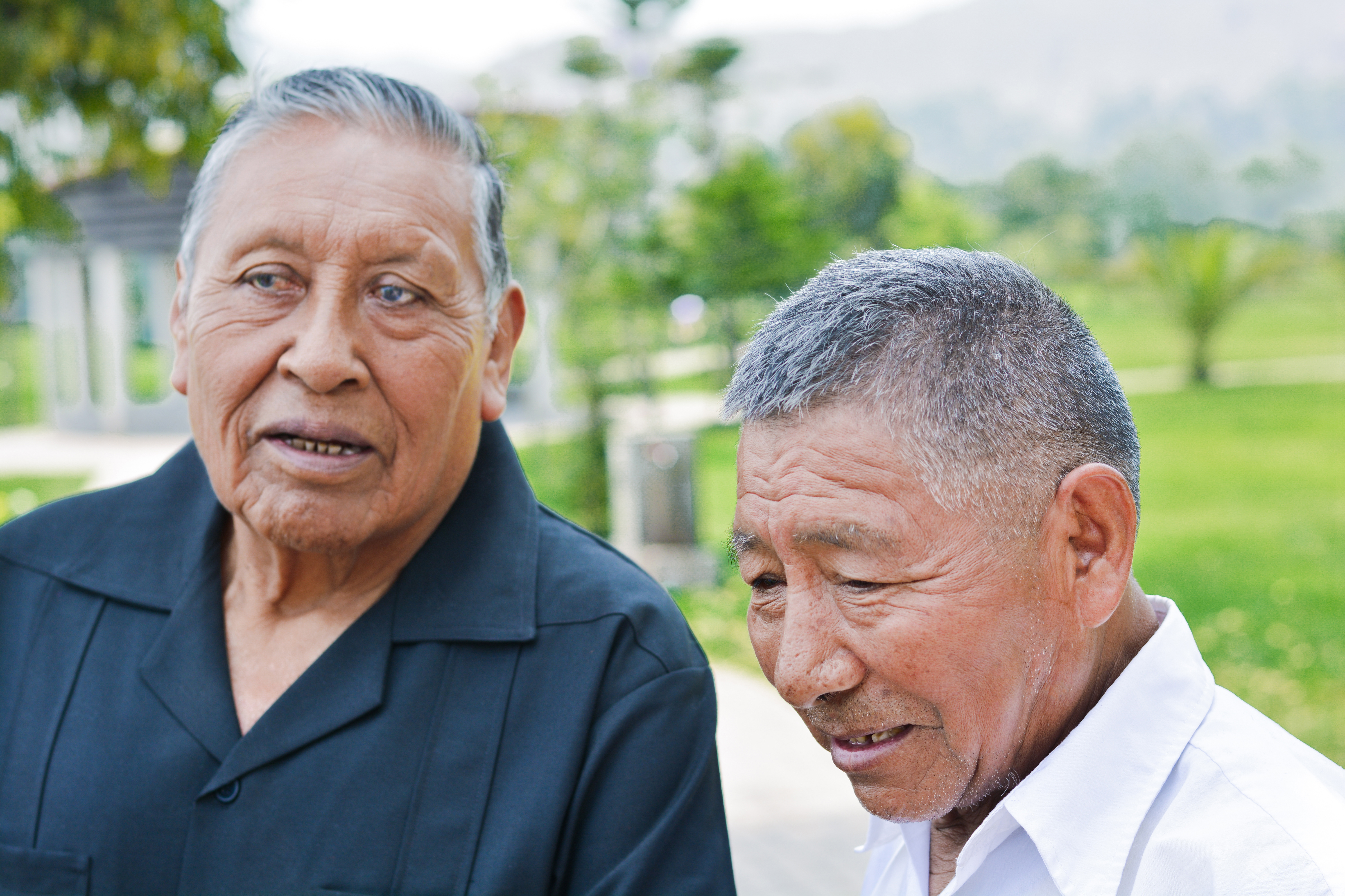 Two older adult men standing next to each other