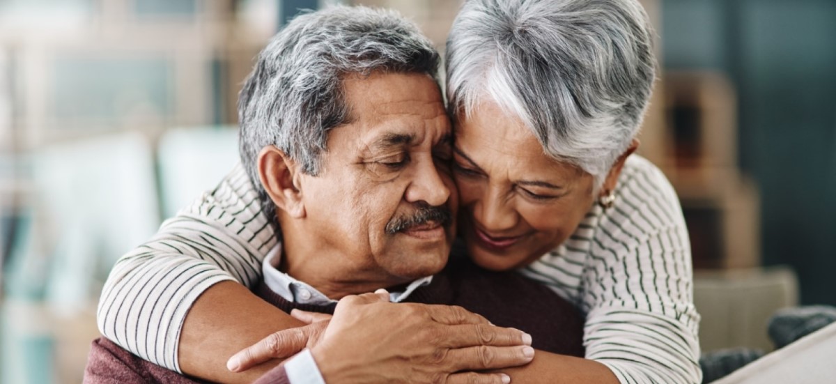 a man and woman smiling and holding each other