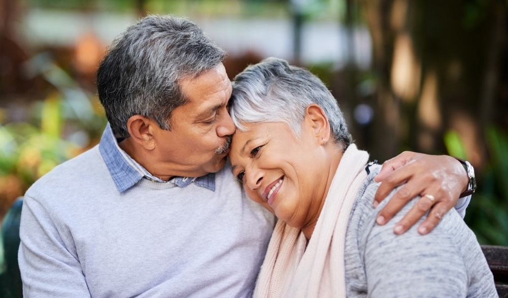 a man and woman smiling and holding each other