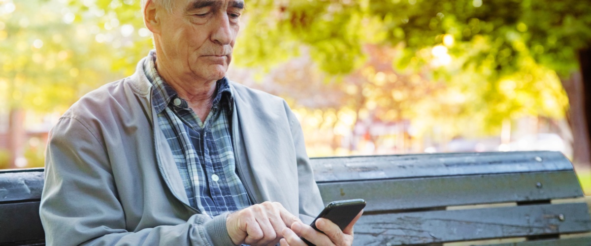 An elderly man using his cell phone to access important information