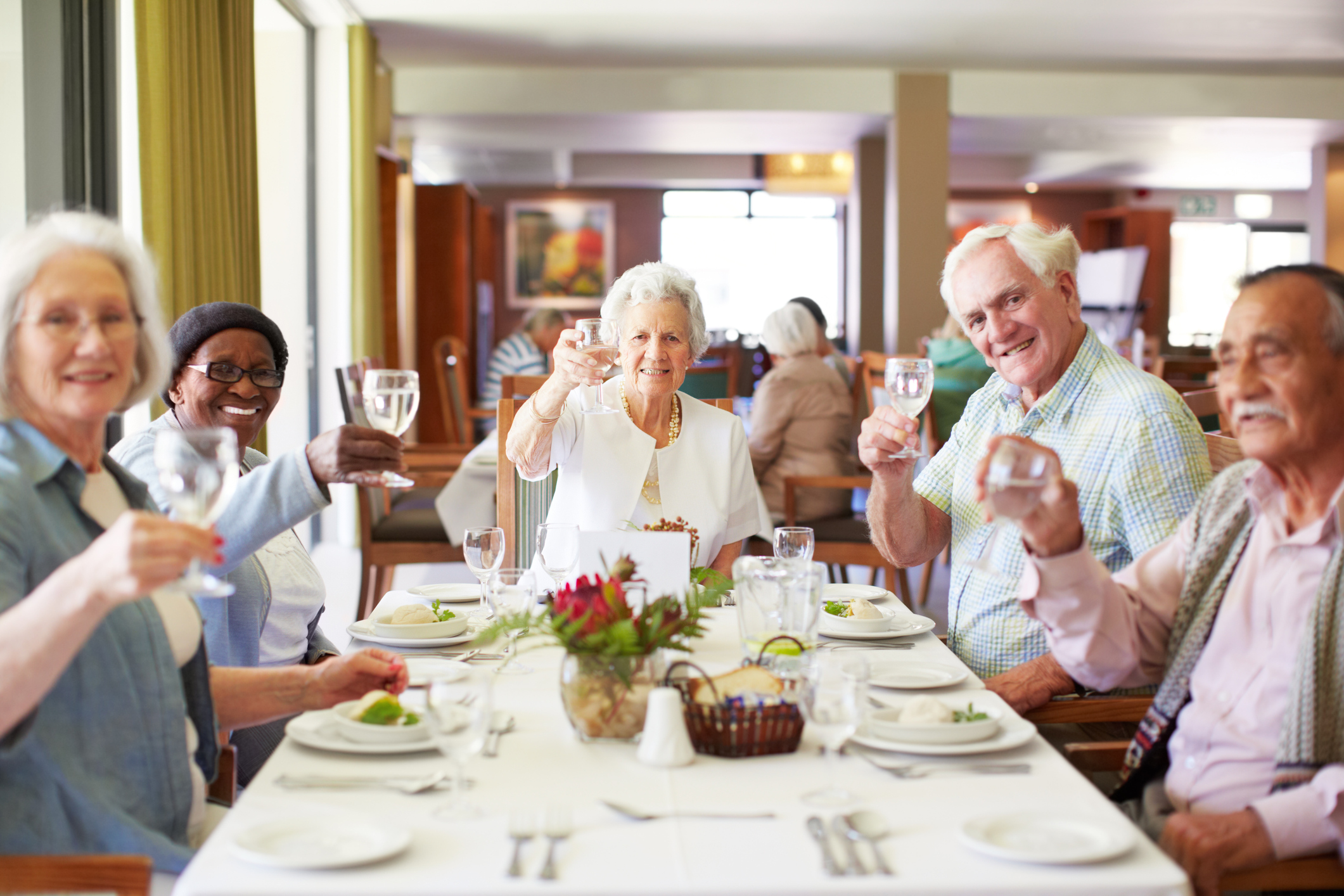 Group of older adults holding up a glass in celebration