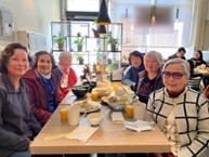 Image of elders sitting and enjoying meal together